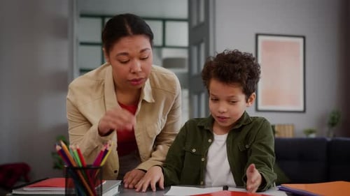 Woman Helping Boy with Homework at Home