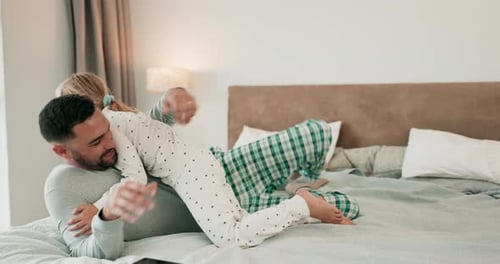 Girl and Father Cuddle on the Bed