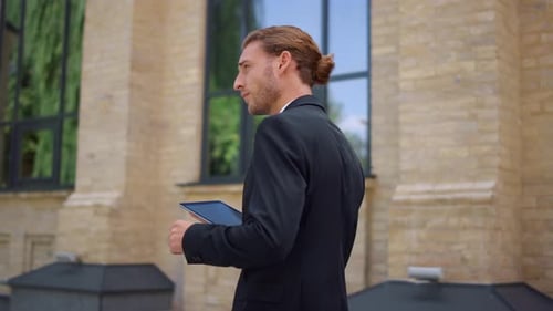 Side View Confident Business Man Working on Digital Tablet During Walk To