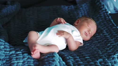 Peaceful Newborn Infant Sleeping on a Blue Blanket