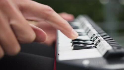 Hands Play Keys on a Small Electronic Keyboard