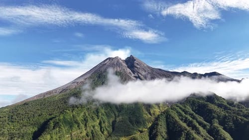 Aerial view footage of Mount Merapi Yogyakarta, beautiful bright blue sky, slightly covered in