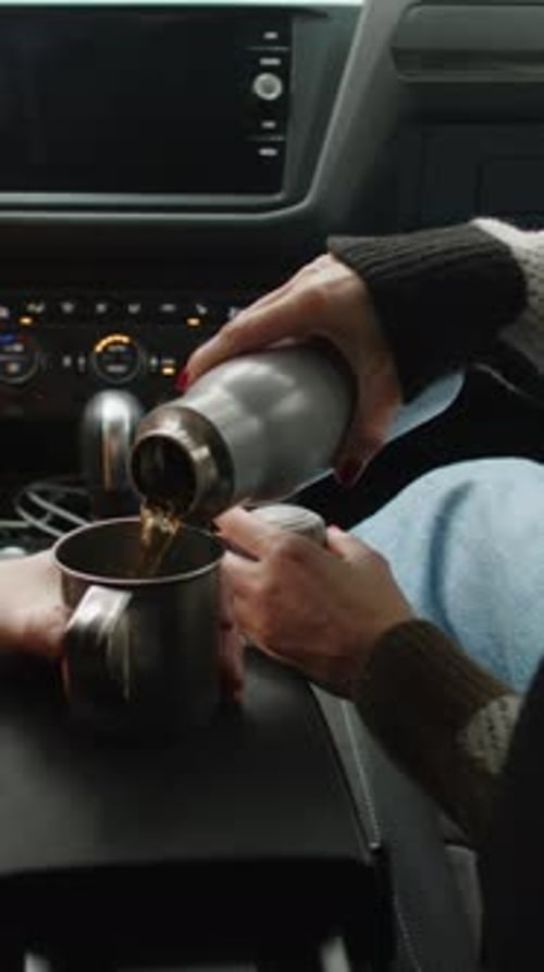 Woman Pouring Steaming Tea for Man in Car