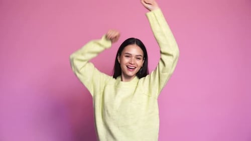 Energetic Woman Dancing Happily on Pink Background