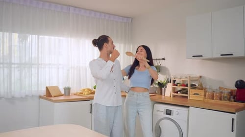 Happy Couple Dancing and Singing in Kitchen
