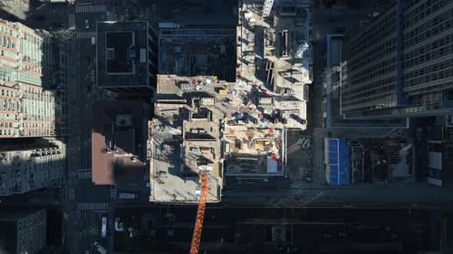 Top Down Showing Crane Building New Skyscraper in Downtown Area Surrounded By Tall Office Buildings