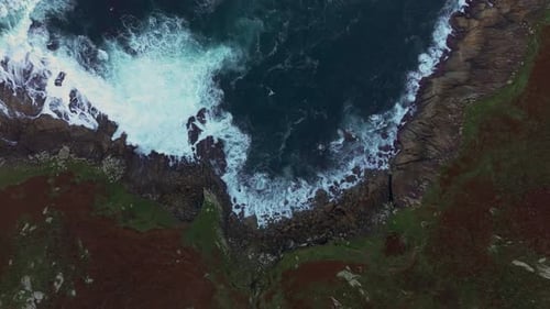 Ocean Waves Crashing On The Rocky Coastline Of Beach. - aerial ascend shot