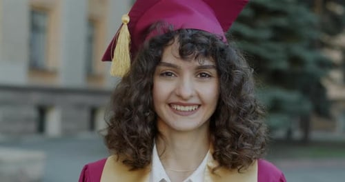 Slow Motion Portrait of Ambitious Lady in Graduation Hat Standing Outdoors Smiling Enjoying Master