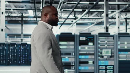 System Administrator Walking in Data Center with Rigs Doing Backups