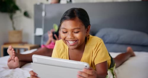Child Enjoying Tablet on Bed at Home