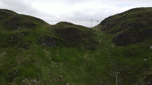 Power lines going over hill in Wales uk aerial footage
