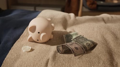 Piggy Bank and Dollar Bills Lying on Bed in Child Bedroom