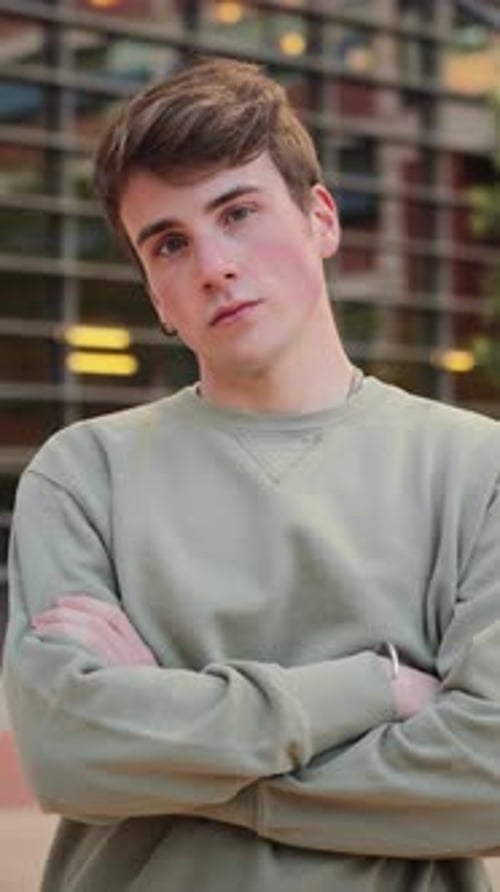 Young Man Posing with Arms Crossed in Urban Setting