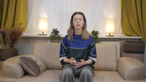 Worried Woman Sitting on Couch Expressing Displeasure