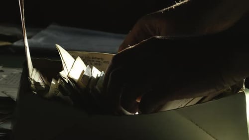 Person Sorting Through a Box of Old Letters