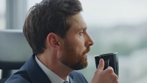 Thoughtful Businessman Taking Break Drinking Coffee At Corporate Office Close Up. Side View Of Ca...