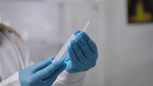 Doctor Holding a Syringe in Blue Gloves for Medical Procedure