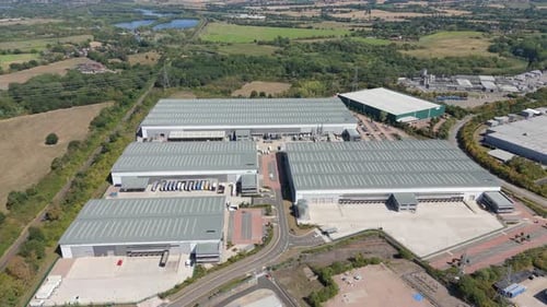 Aerial view of warehouses and surrounding greenery, United Kingdom.