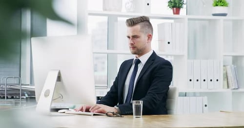 4k video footage of a young businessman working on a computer in an office
