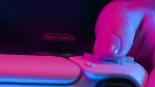Gamer's Hands Playing Online Video Game on Console TV with Joystick Neon Color Light