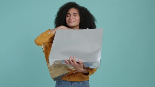 Woman Smiling With Shopping Bags in Studio