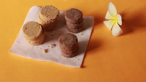 Plate full of oatmeal cookies with sesame seeds being snatched up by four children. Close up, top vi