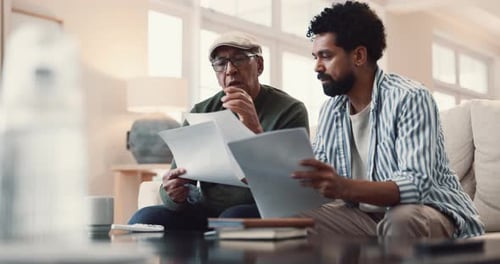 Adult and Senior Reviewing Paperwork Together Indoors