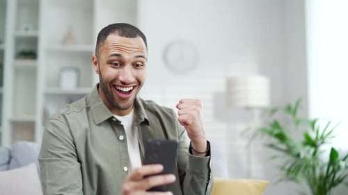 Man Reacts to Good News on Mobile Phone