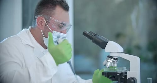 Scientist Working With Microscope and Samples in Lab