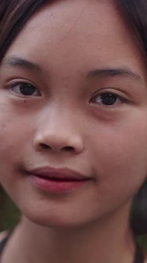 Slow Motion Face of Young Asian Teenager Girl Looking Smiling at Camera Calm in Garden