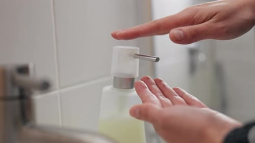 Aufrechterhaltung der Sauberkeit durch Auftragen von Flüssigseife auf die Hände, Waschen einer Person, die einen Seifenspender benutzt