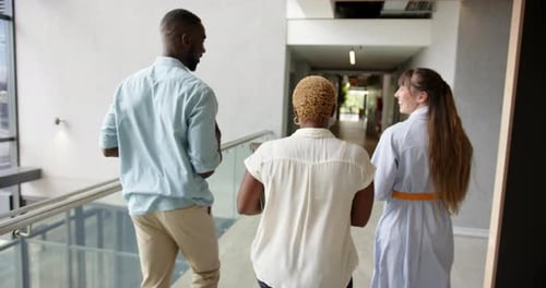 Beim Gang durch den Flur diskutieren verschiedene Kollegen über die Arbeit in einem modernen Bürogebäude