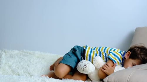 Boy Playing Doctor with Stuffed Animal Toy at Home