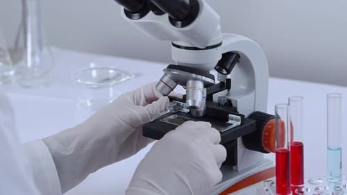 Close Up of Microscope with Scientist Examining Sample