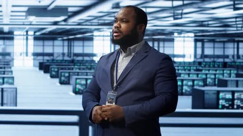 System Administrator Looking at Holograms in Data Center Monitoring Equipment