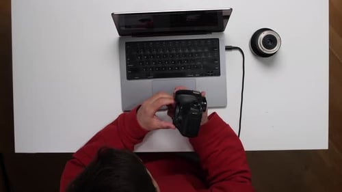 Top View Photographer Connecting Camera to Laptop for Editing Photos
