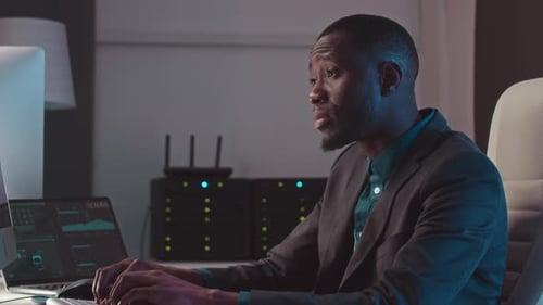 Man Coding at Computer in Modern Tech Office