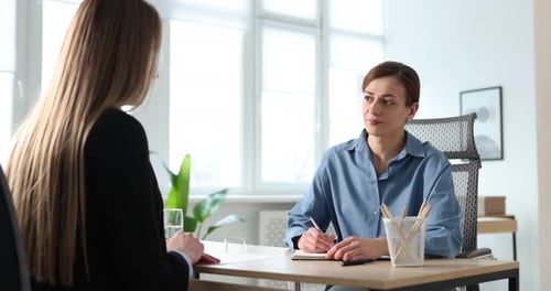 Smiling recruiter and candidate having job interview at table in office