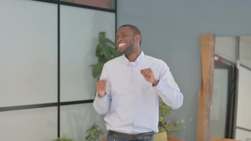 Dancing African Businessman enjoying in Office