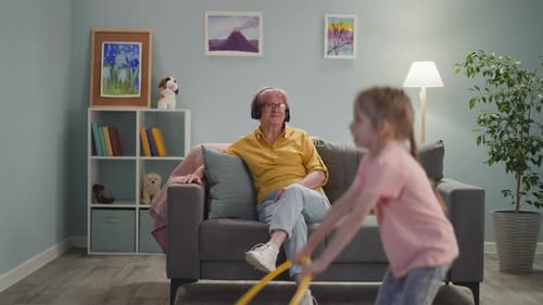 Senior Woman Relaxing While Child Plays With Hula Hoop