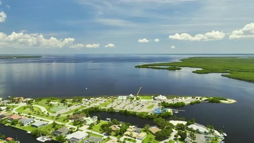 Aerial View of Residential Suburbs with Private Homes Located Near Wildlife Wetlands with Green