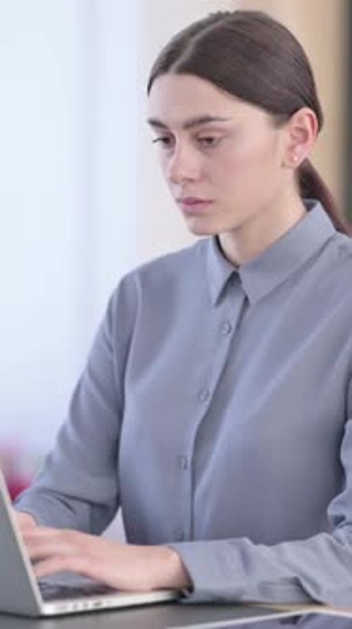 Woman Types on Laptop then Stands up in Office