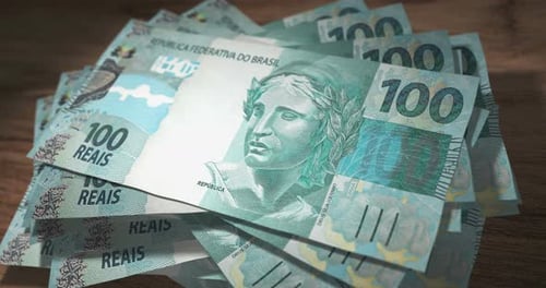 Brazil Real 100 money banknotes falling on the table