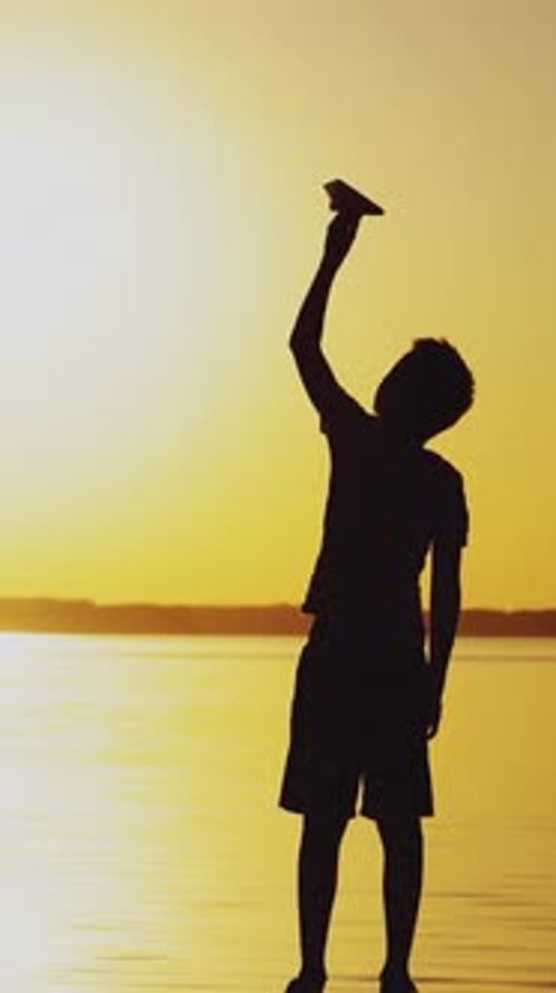 Happy child is playing with a paper airplane.