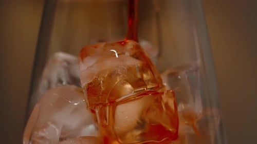 Pouring a Red Alcoholic Drink into a Glass with Ice, Close-Up, Slow Motion.