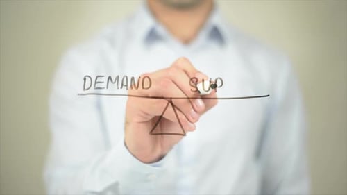 Man Drawing Demand and Supply Scale Illustration