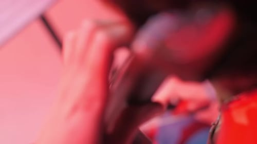 Woman playing violin under red light close up