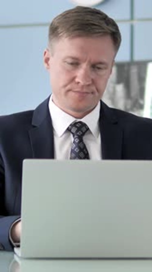 Professional Man Talking on Laptop in Business Setting