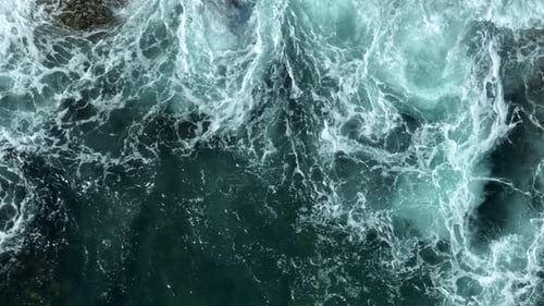 Powerful ocean waves crashing on rocky coastline.