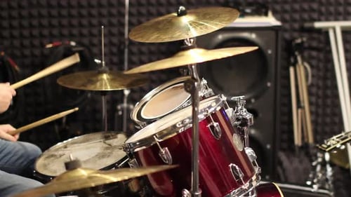 A musician drummer plays a drum kit in a recording studio. Drumming in the rehearsal base